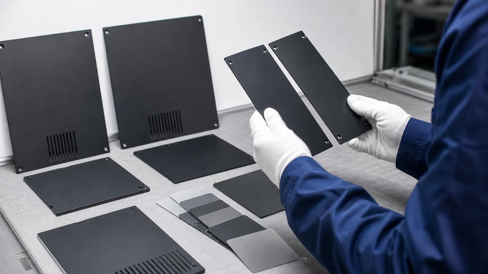 Black anodized aluminum enclosure covers compared for subtle color variation
